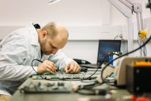 technician fixing motherboard by soldering 2023 11 27 05 31 10 utc min